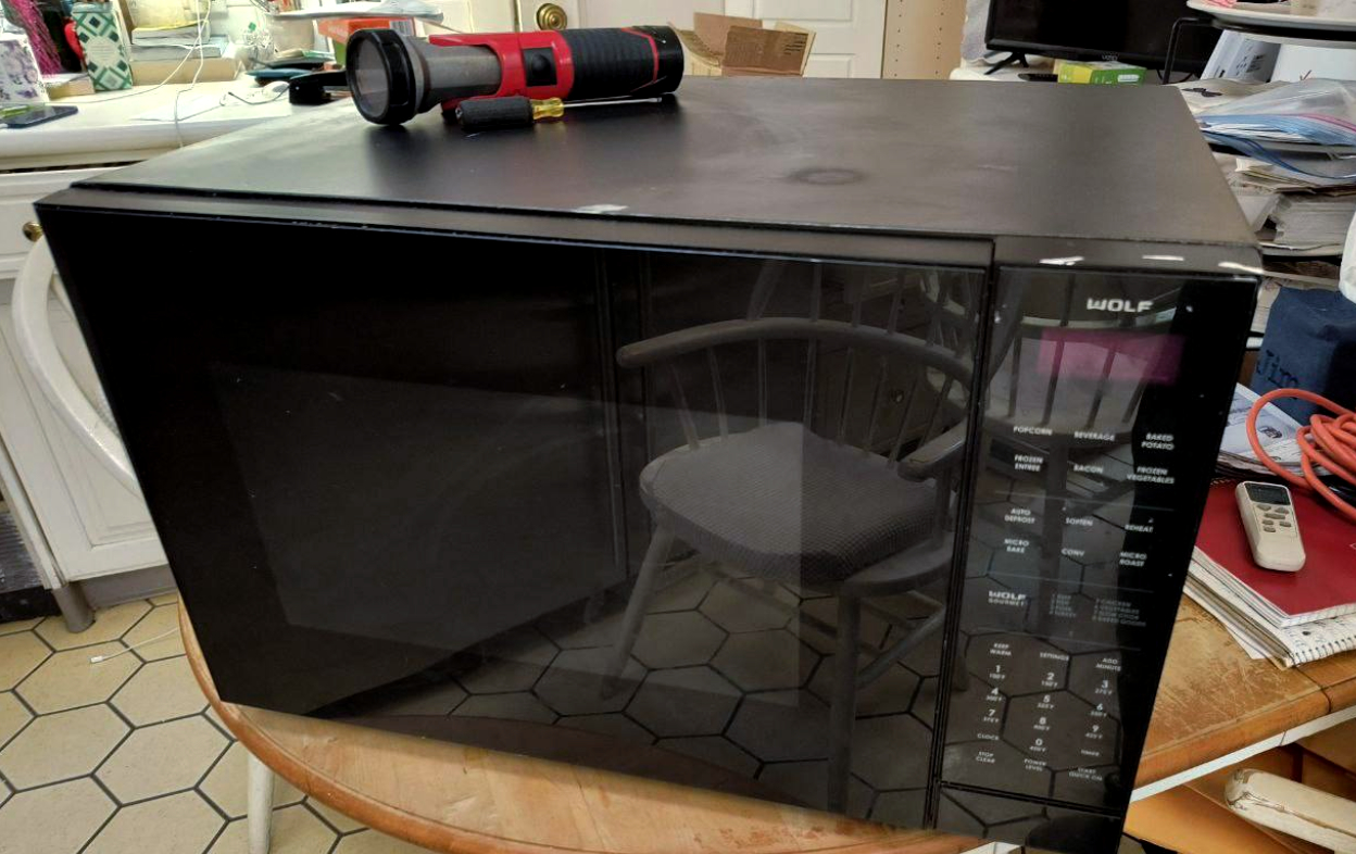Wolf microwave on workbench during repair — testing door switches, keypad, and heating system in Houston, TX